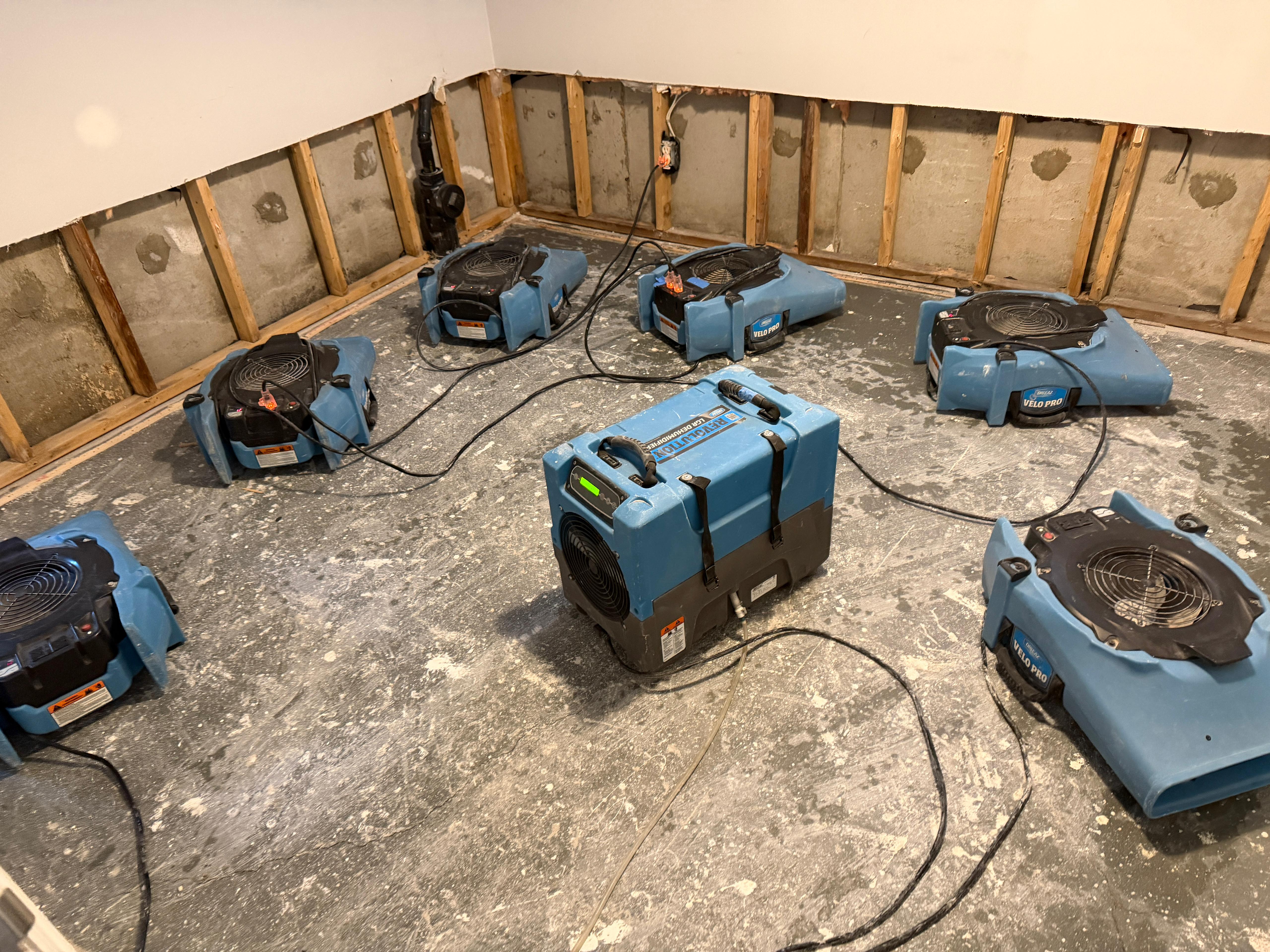 Industrial drying equipment deployed in flood-damaged basement